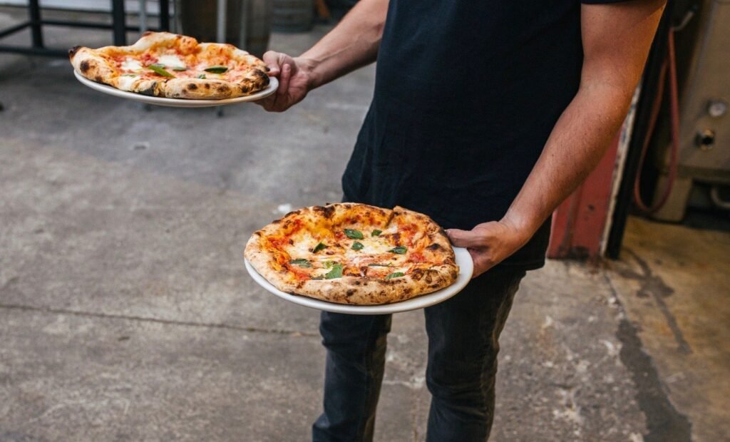 Man-holding-pizzas-CROPPED.jpg